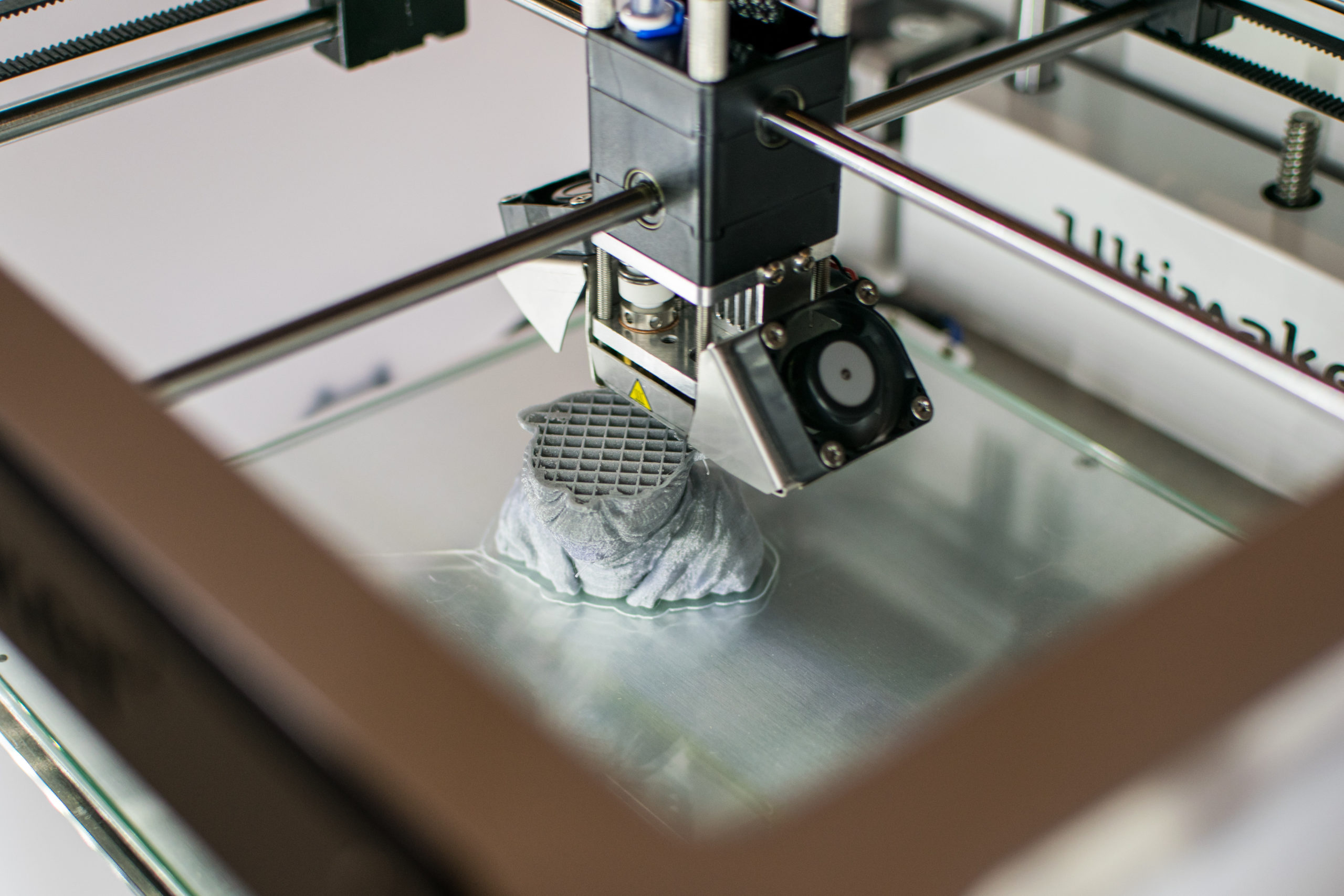 Imprimante 3D en cours d'impression d'un Yoda en résine grise dans un des laboratoires numériques.